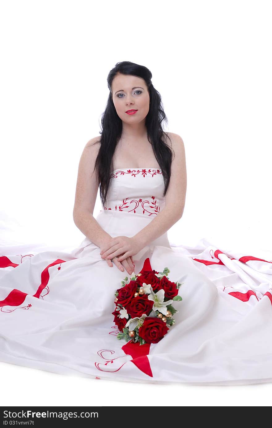 Photograph showing cute young bride in white and red wedding dress isolated against white