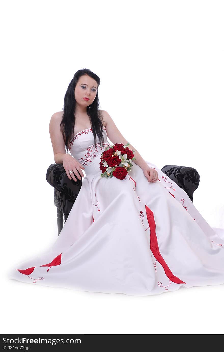 Photograph showing cute young bride in white and red wedding dress isolated against white sat on lounger