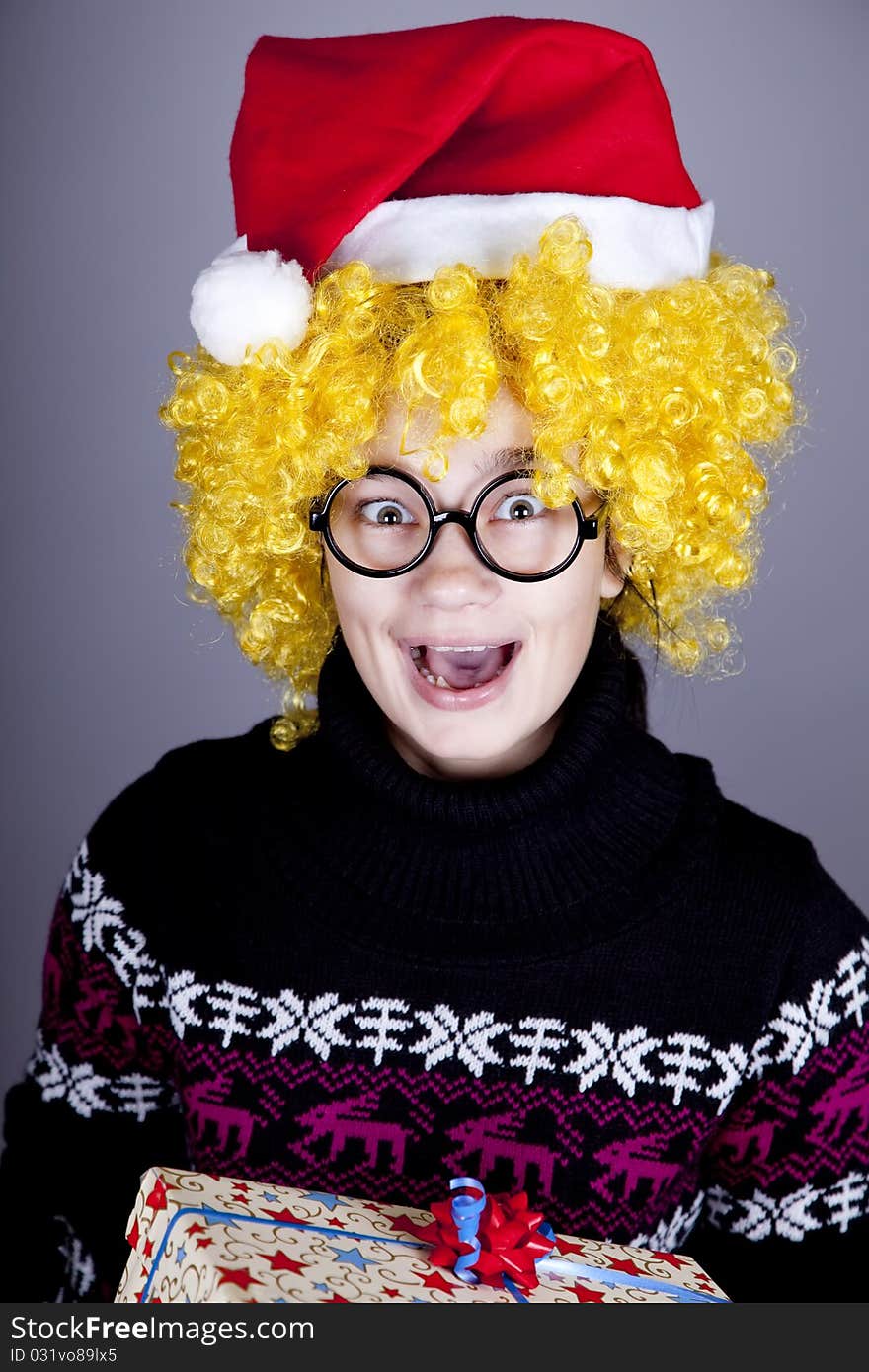 Funny girl in glasses with christmas gifts. Studio shot.