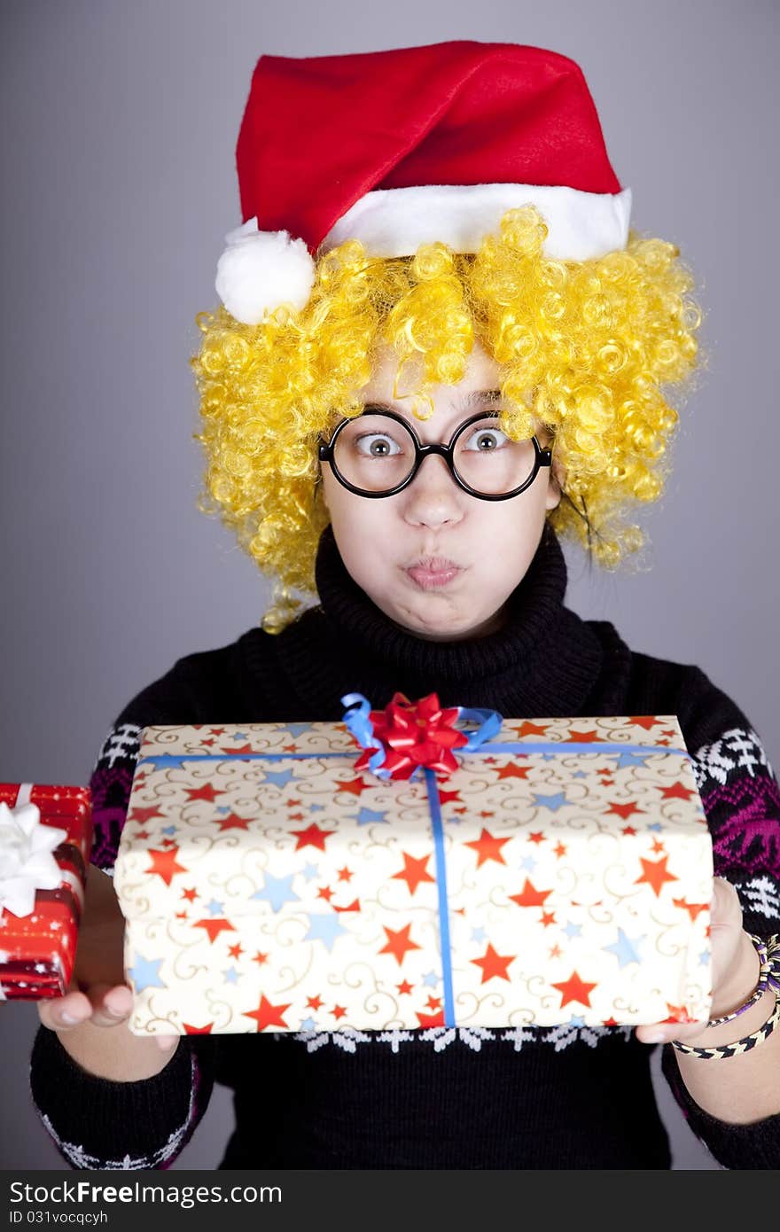 Funny girl in glasses with christmas gifts. Studio shot.