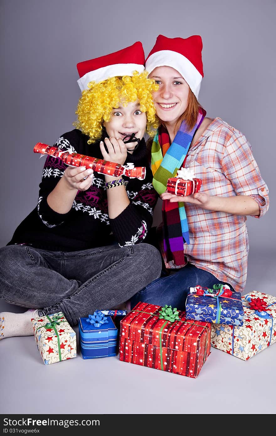 Two funny girls with christmas gifts.