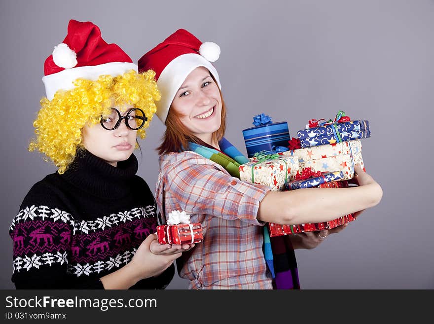 Two funny girls with christmas gifts.