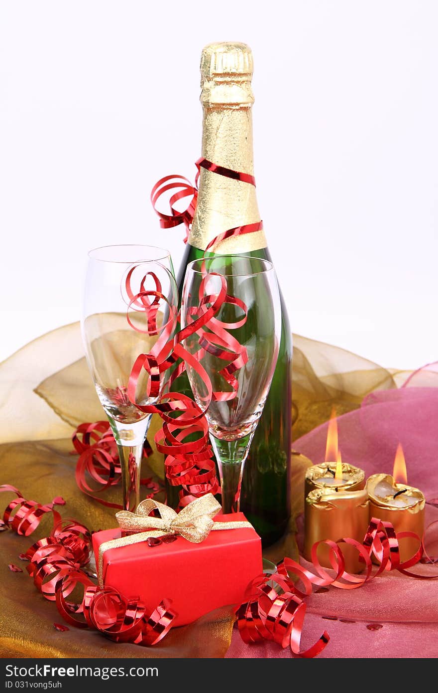 Bottle of champagne, glasses, candles and a gift. Bottle of champagne, glasses, candles and a gift