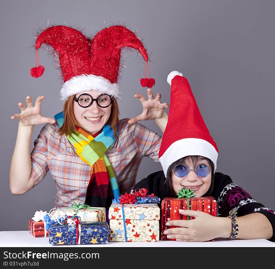 Two funny girls with christmas gifts.