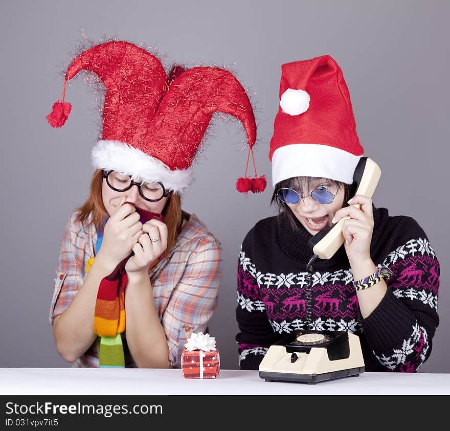 Two girls calling to Santa for better christmas gift. Studio shot.