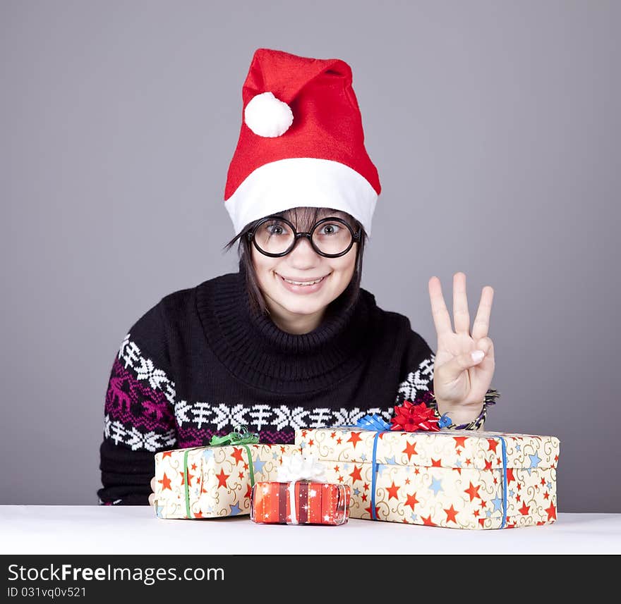 Funny girl in glasses with christmas gifts.