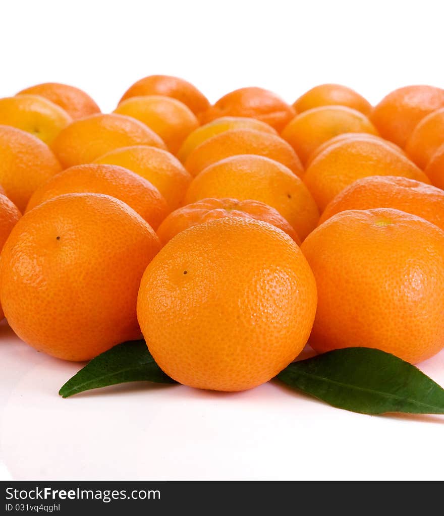 Oranges and green leaves isolated on white background