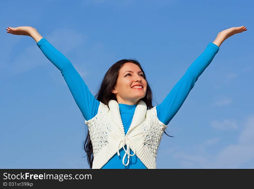 A young woman stretches her hand towards the sky. A young woman stretches her hand towards the sky