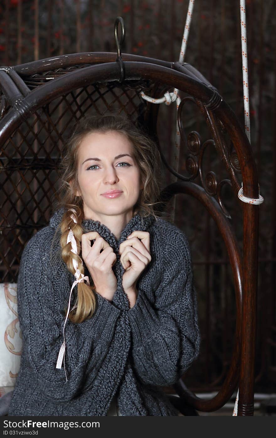 Beautiful blond girl with plait on the swing