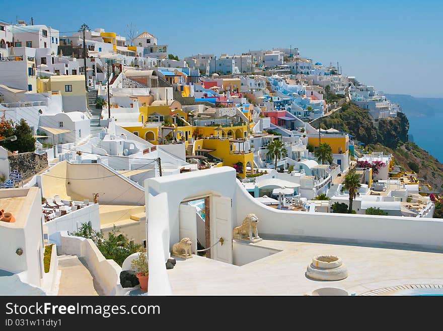 Landscape of city Fira with traditional houses on island of Santorini, Greece. Arch with statue of lions is in front. Landscape of city Fira with traditional houses on island of Santorini, Greece. Arch with statue of lions is in front.