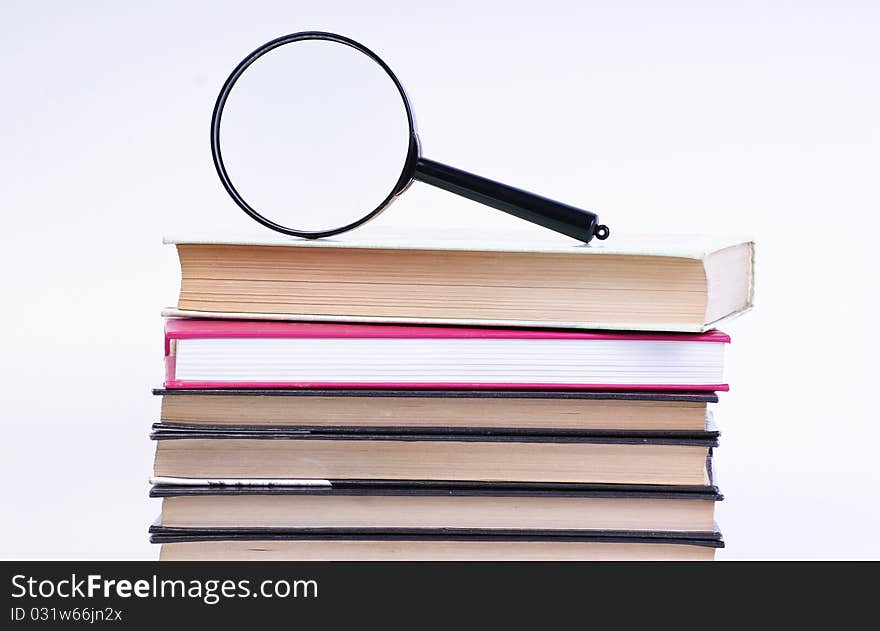 Book with magnifying glass on white background