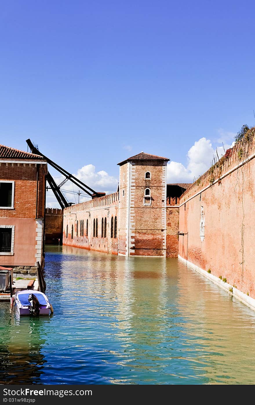 Reflections of the brick wall and tower in the canal in Venice. Reflections of the brick wall and tower in the canal in Venice