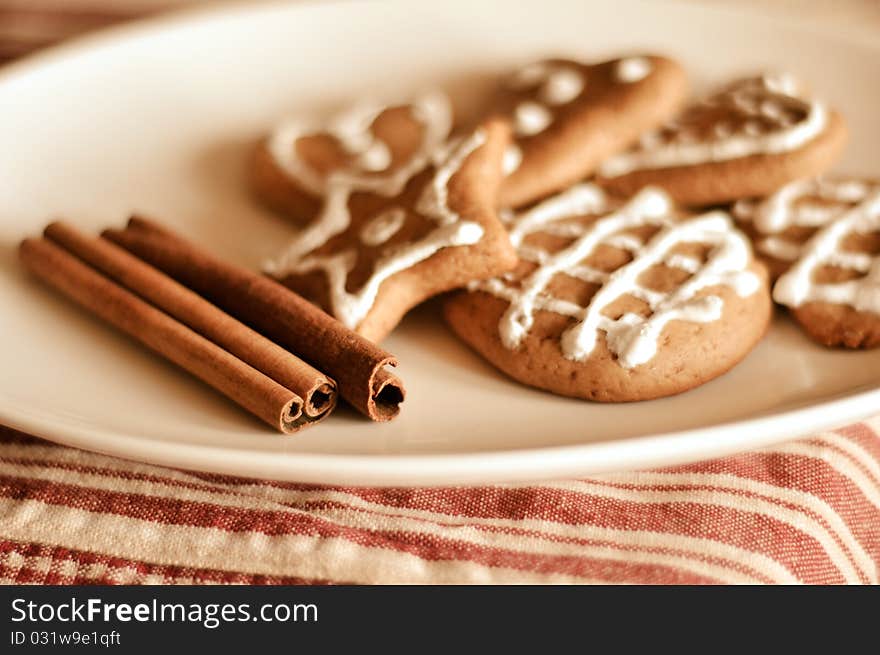 Plate of decorated cookies and sticks of the cinnamon. Plate of decorated cookies and sticks of the cinnamon