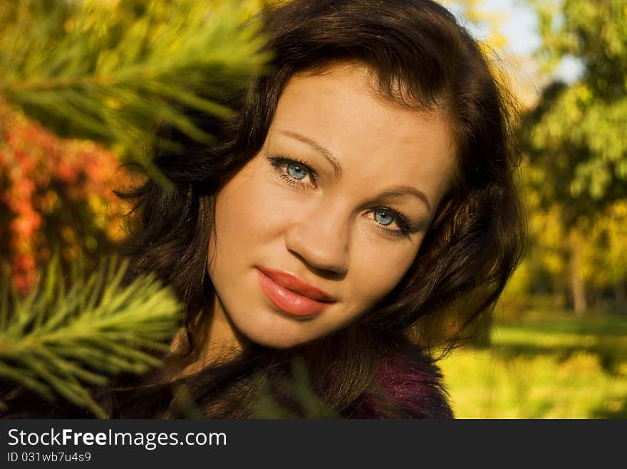 Pretty young woman smiles on the background of autumn trees. Pretty young woman smiles on the background of autumn trees