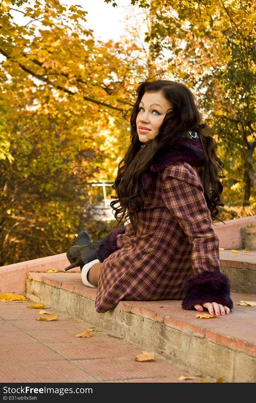 Beautiful glamour girl sits on the stair