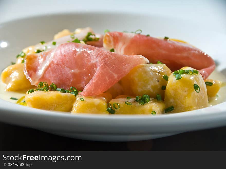 Pumpkin gnocchi with thin sliced ham and chives