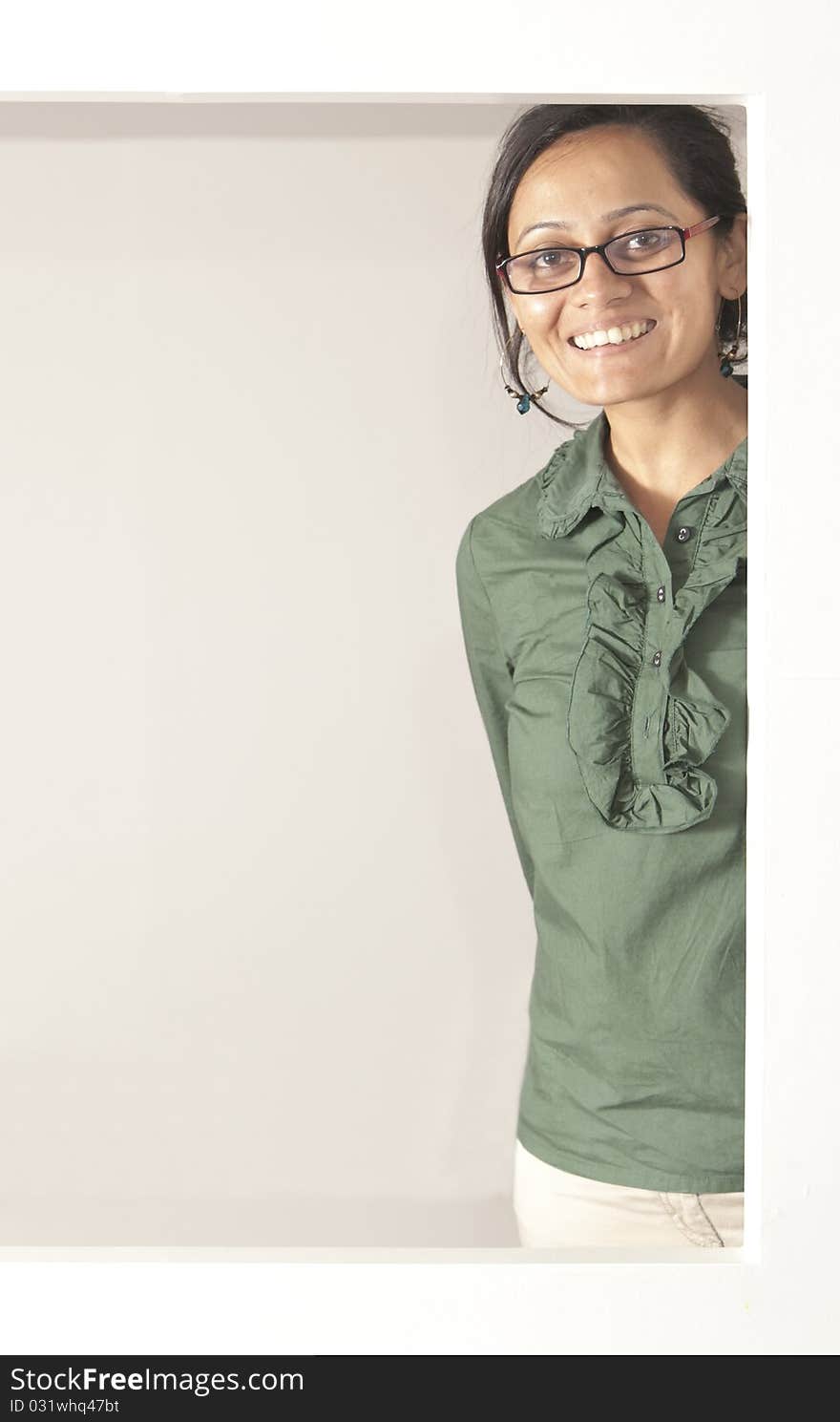 Smiling indian woman at an opening, jade green top and light pants wearing glasses. Smiling indian woman at an opening, jade green top and light pants wearing glasses