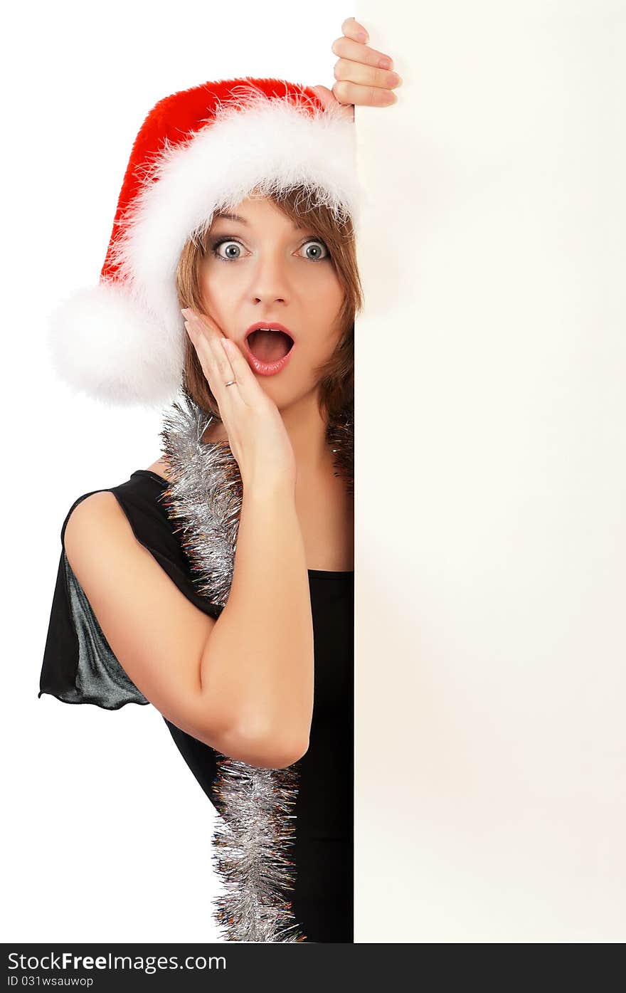 Emotional beautiful christmas girl wearing Santa hat, holding a white blank. Isolated on white background.