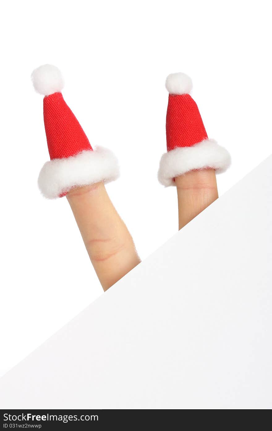 Clear sheet of paper with two fingers in small Santas caps isolated on white, copy space. Clear sheet of paper with two fingers in small Santas caps isolated on white, copy space