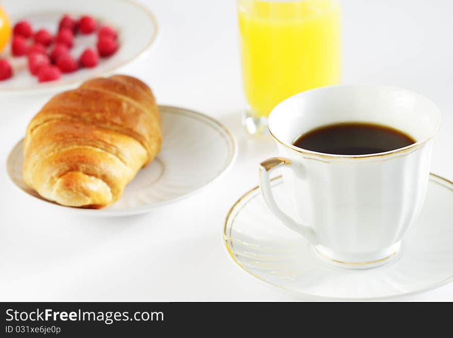 Breakfast. A cup of coffee and croissant