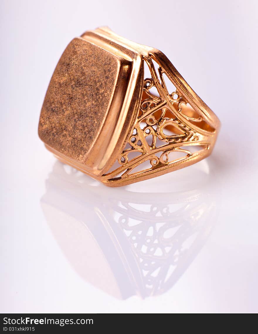 Old gold ring with reflection on light background