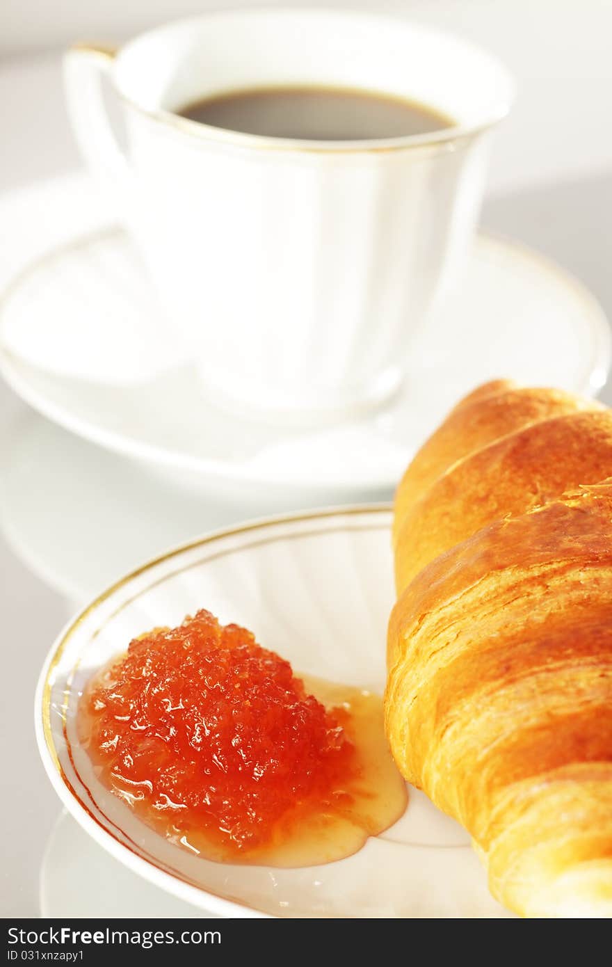 Breakfast with coffee and croissant on a bright background