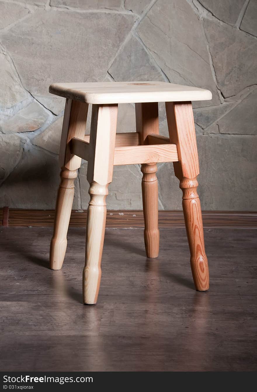 Wooden chair against a background of stone. Wooden chair against a background of stone