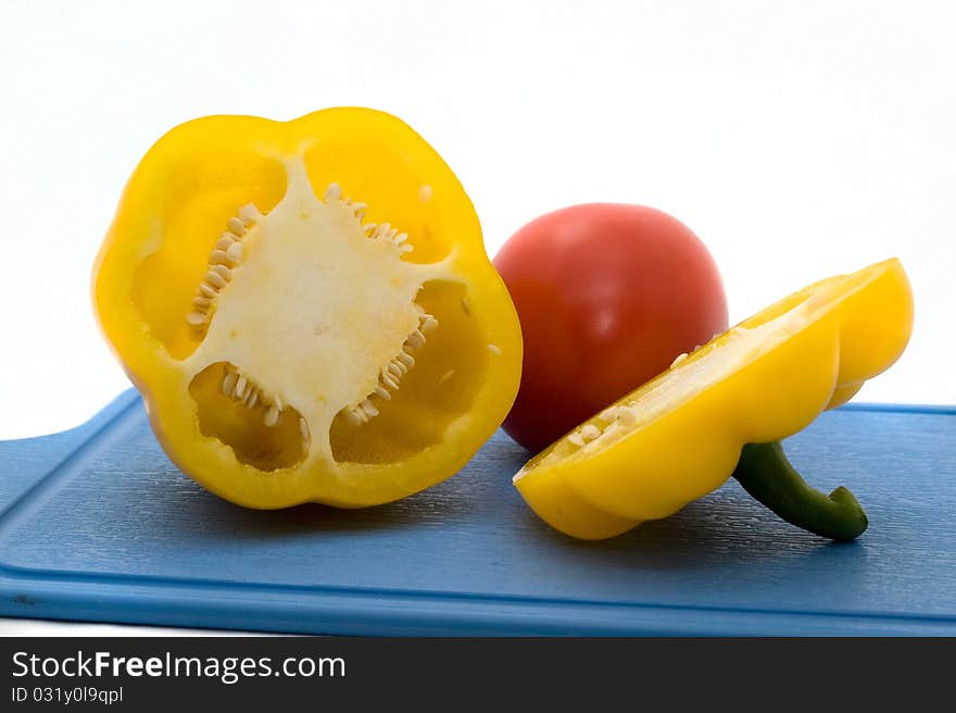 Fresh, colorful pepper and tomato on a white background closeup. Fresh, colorful pepper and tomato on a white background closeup