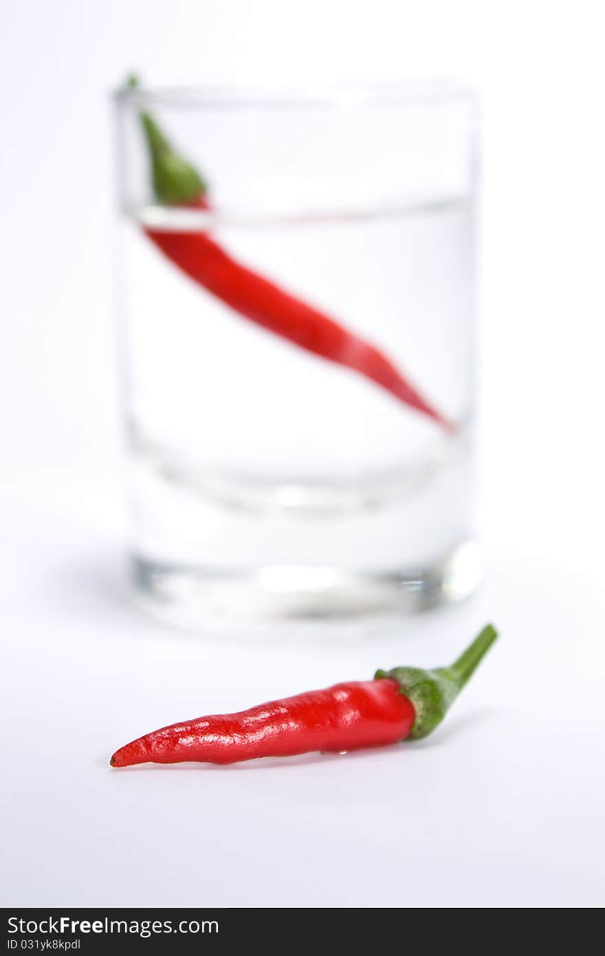 Red pepper against with a vodka wine-glass