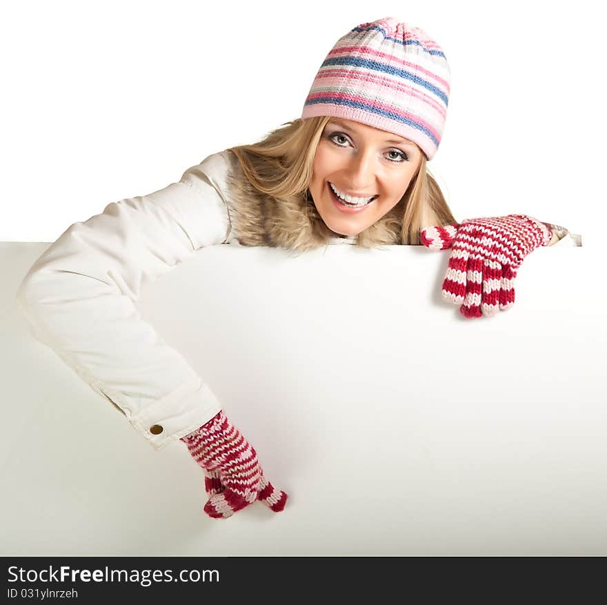 Woman in colorful hat and gloves peeping from behind whiteboard isolated on white. Woman in colorful hat and gloves peeping from behind whiteboard isolated on white