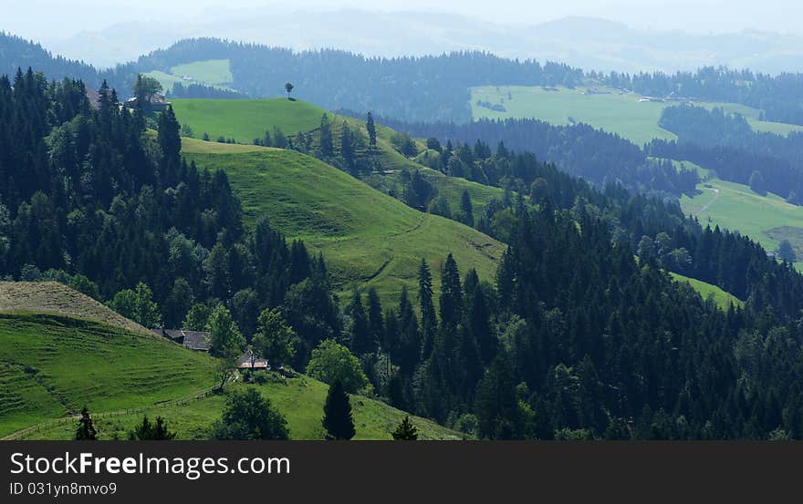 The green hills of the Swiss Emmental region (foothills of the Alps) is where the famous Swiss cheese comes from. The picture is taken from an area south of the village of Sumiswald in Berne county.