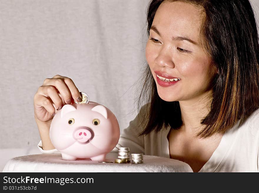 Young woman with pink piggy bank