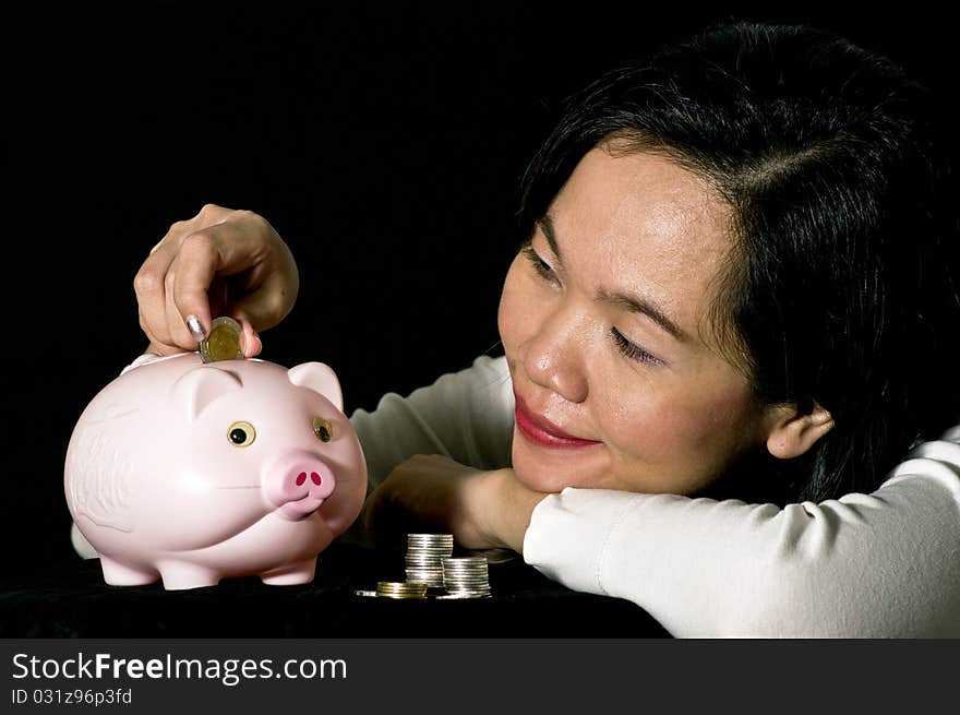 Young woman with pink piggy bank