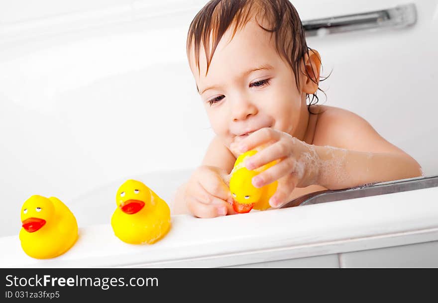 Beautiful little boy taking a relaxing bath and playing with toy ducks. Beautiful little boy taking a relaxing bath and playing with toy ducks