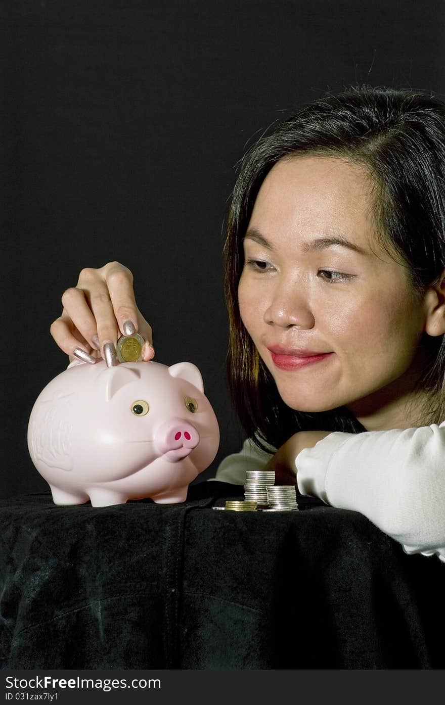 Young woman with pink piggy bank