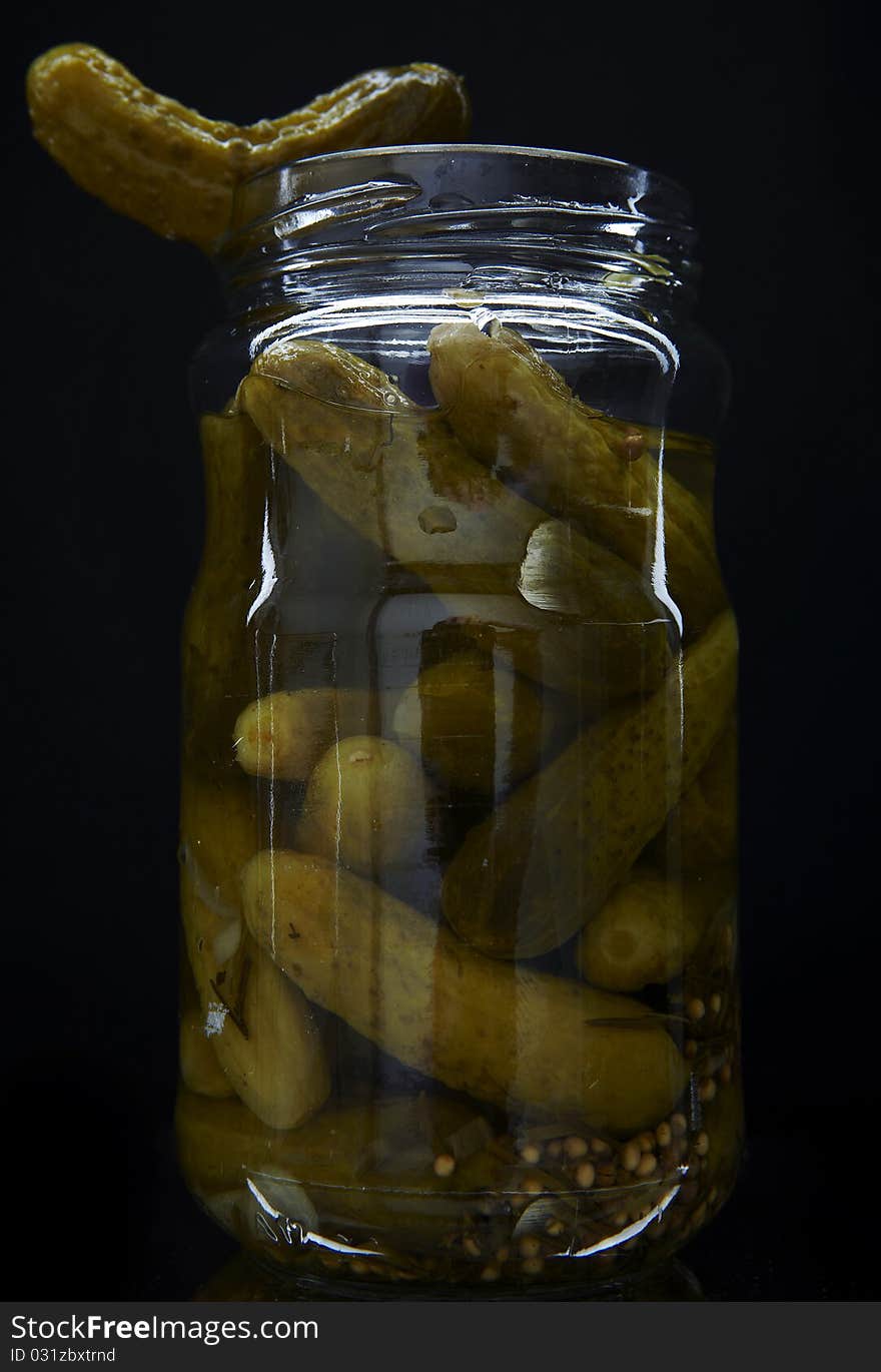 Cucumber vegetables canned in glass jars. Photo.