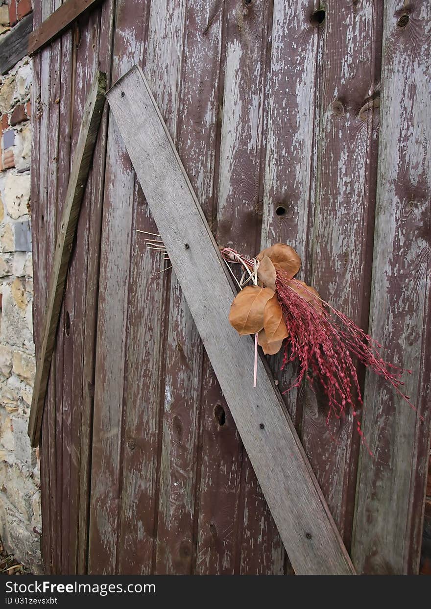 Old Door With A Bouquet Of Dried Grass