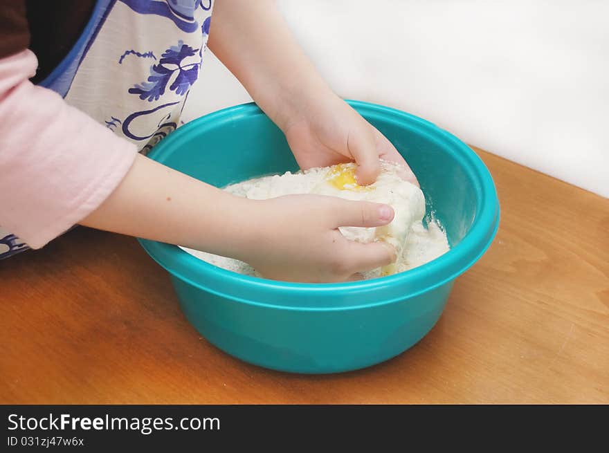 Child hands kneading a dough