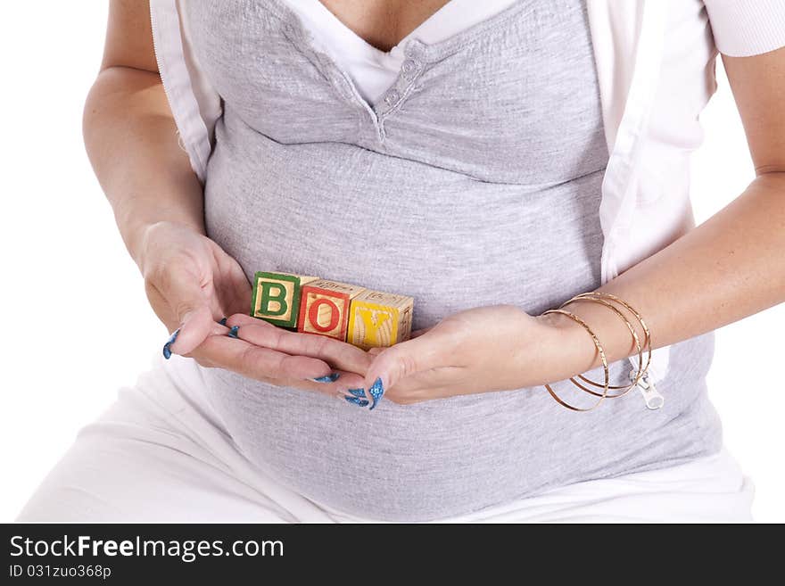 A close up of a woman who is pregnant holding blocks that spell out the word boy. A close up of a woman who is pregnant holding blocks that spell out the word boy.