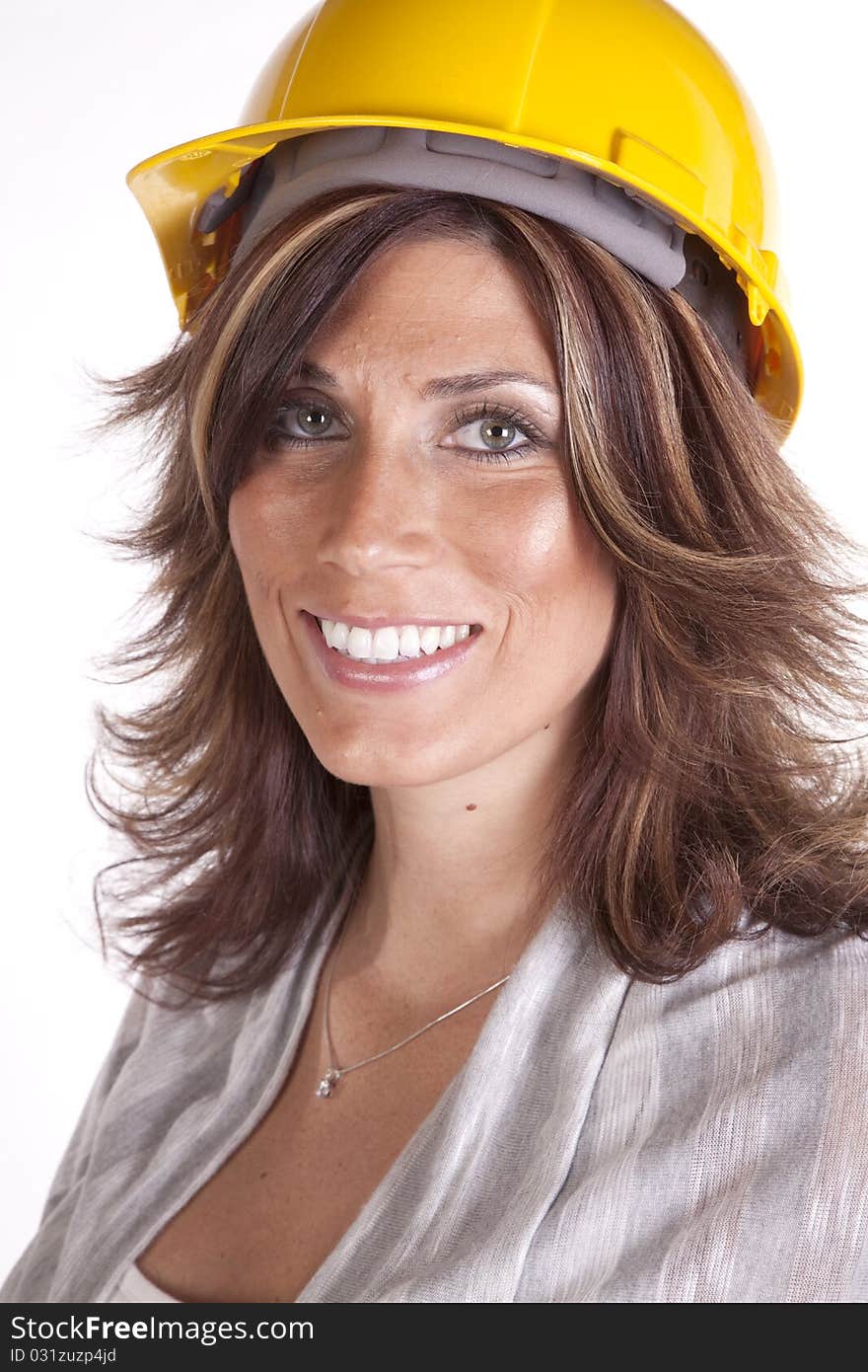 A close up of a woman wearing a yellow hard hat with a smile on her face. A close up of a woman wearing a yellow hard hat with a smile on her face.