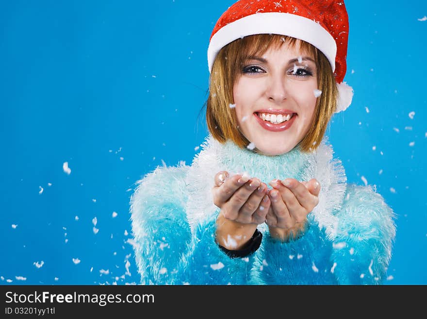 Lovely girl catch the snow at Christmas time, blue background