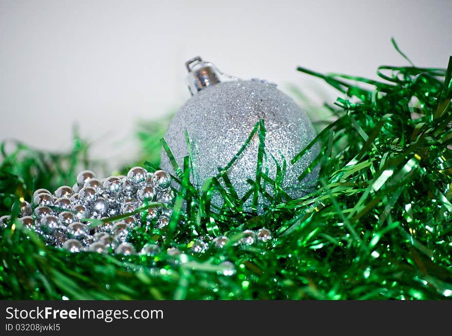 Silver and green Christmas balls laying on the table, white background. Silver and green Christmas balls laying on the table, white background