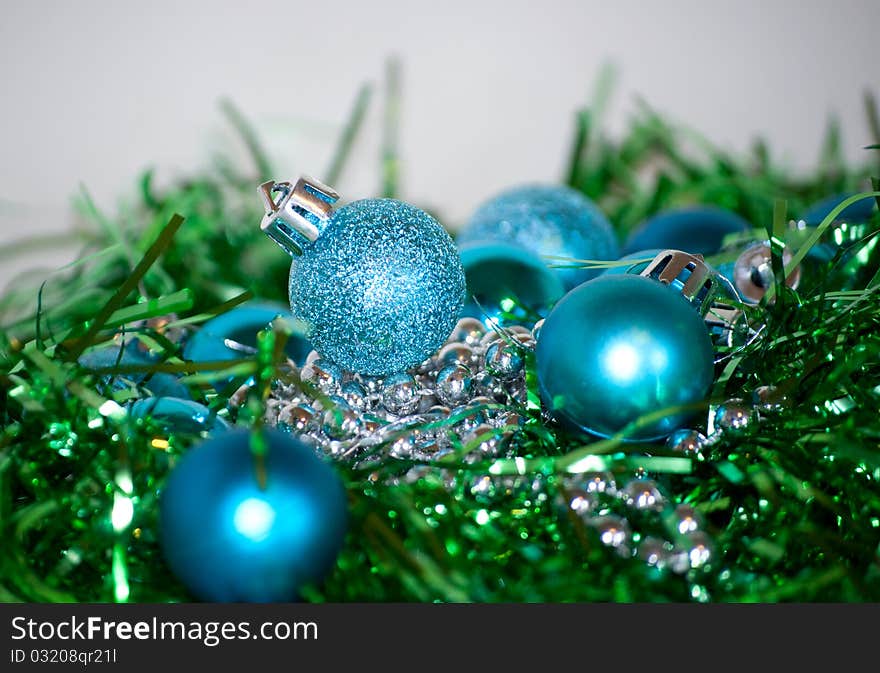 Blue and green Christmas balls laying on the table, white background. Blue and green Christmas balls laying on the table, white background