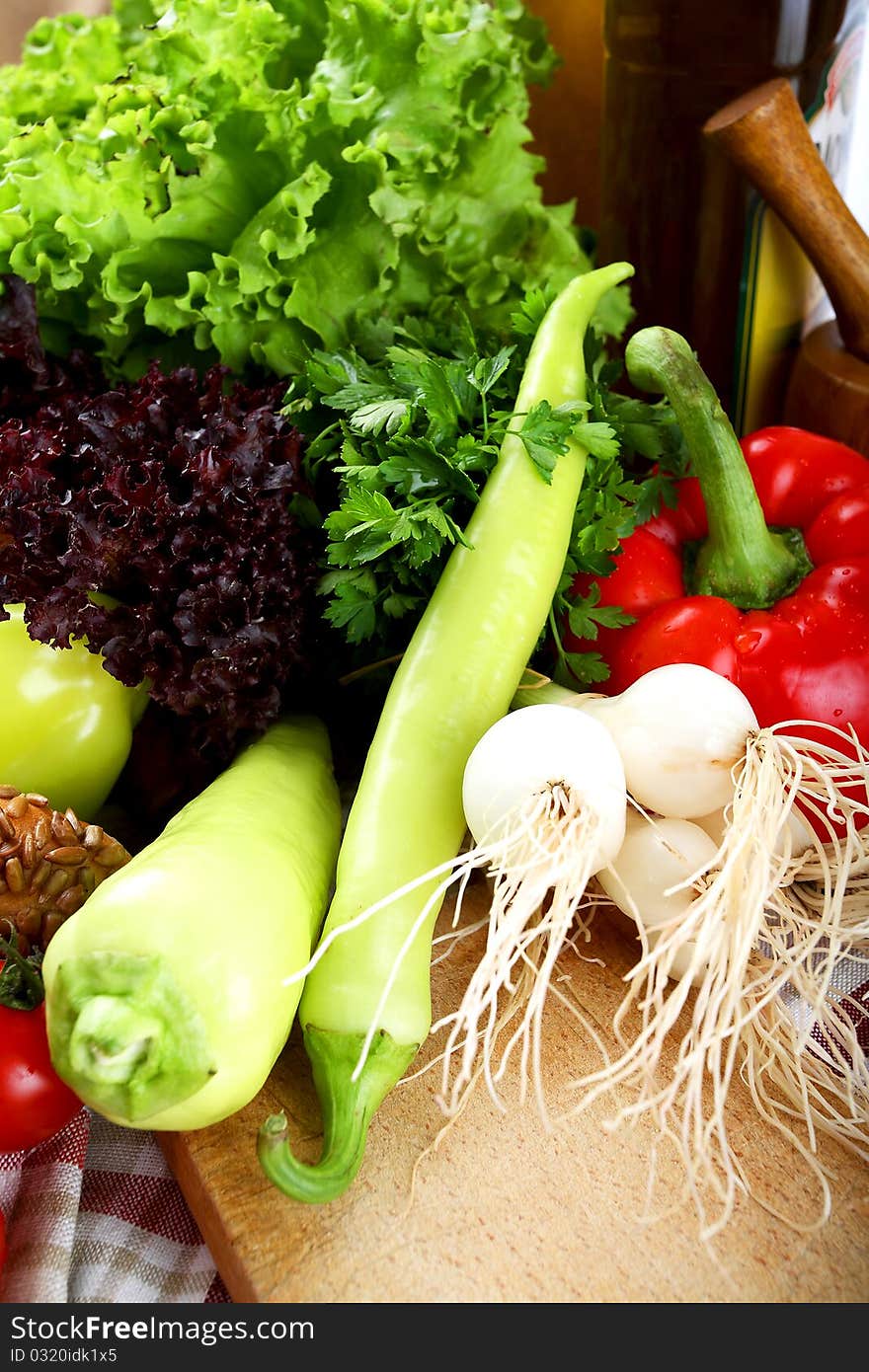 Vegetables and the bottle of olive oil placed on a kitchen table