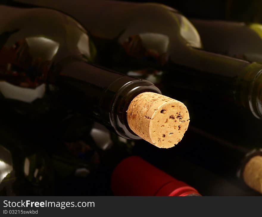 Bottles of wine in rows in wine cellar.