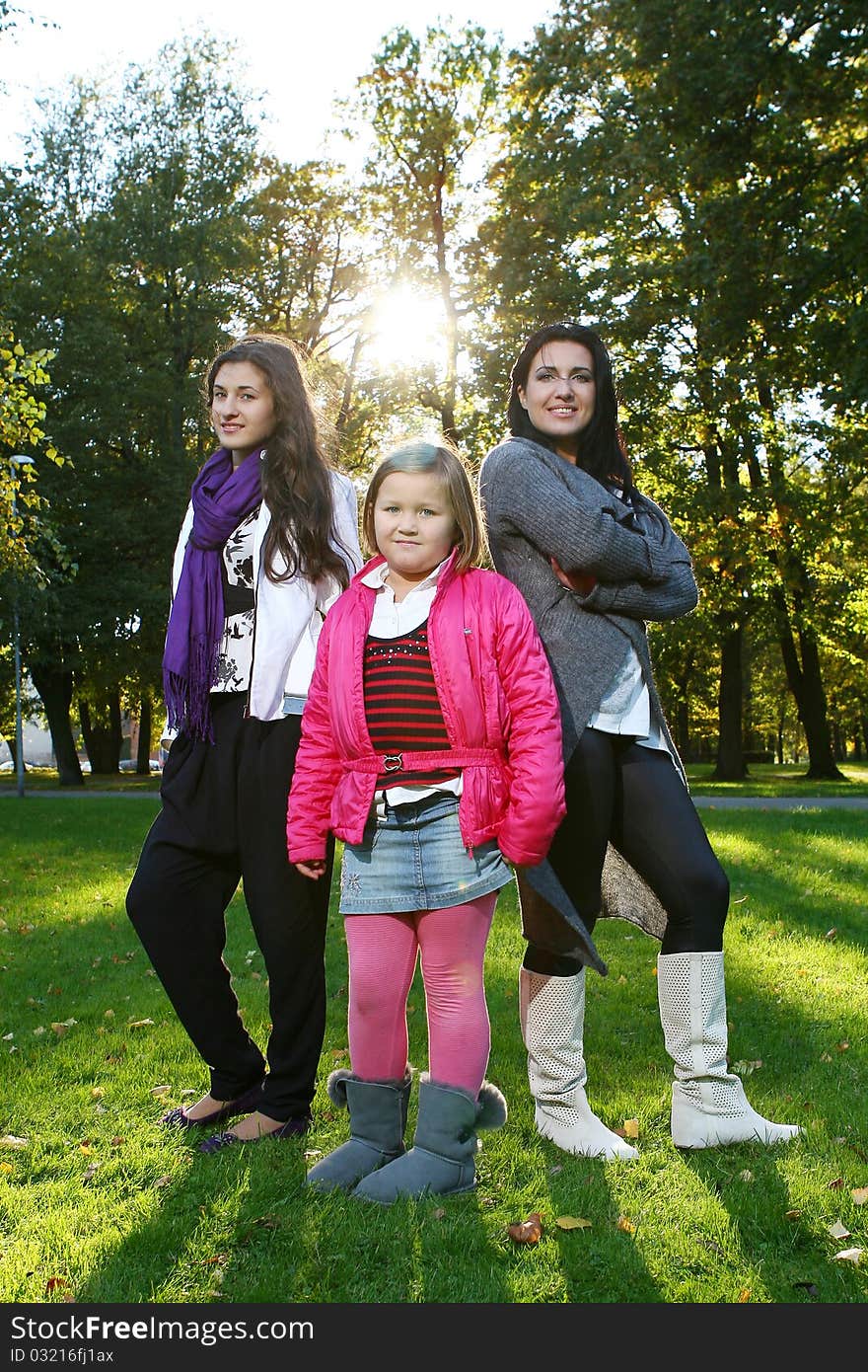 Young family taking healthy stroll through autumn park and have fun. Young family taking healthy stroll through autumn park and have fun