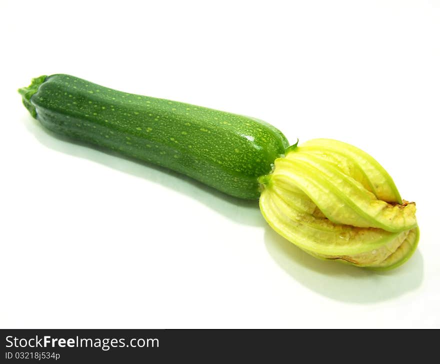 A green courgette on a white background. A green courgette on a white background.