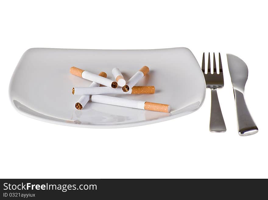 Several cigarettes on the plate with fork and knife. Several cigarettes on the plate with fork and knife