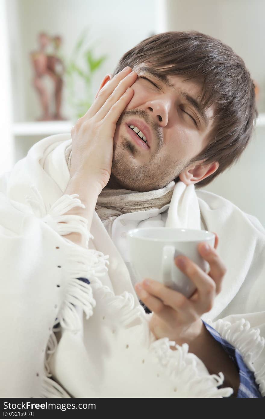 Young man with headache or toothache on the sofa. Young man with headache or toothache on the sofa