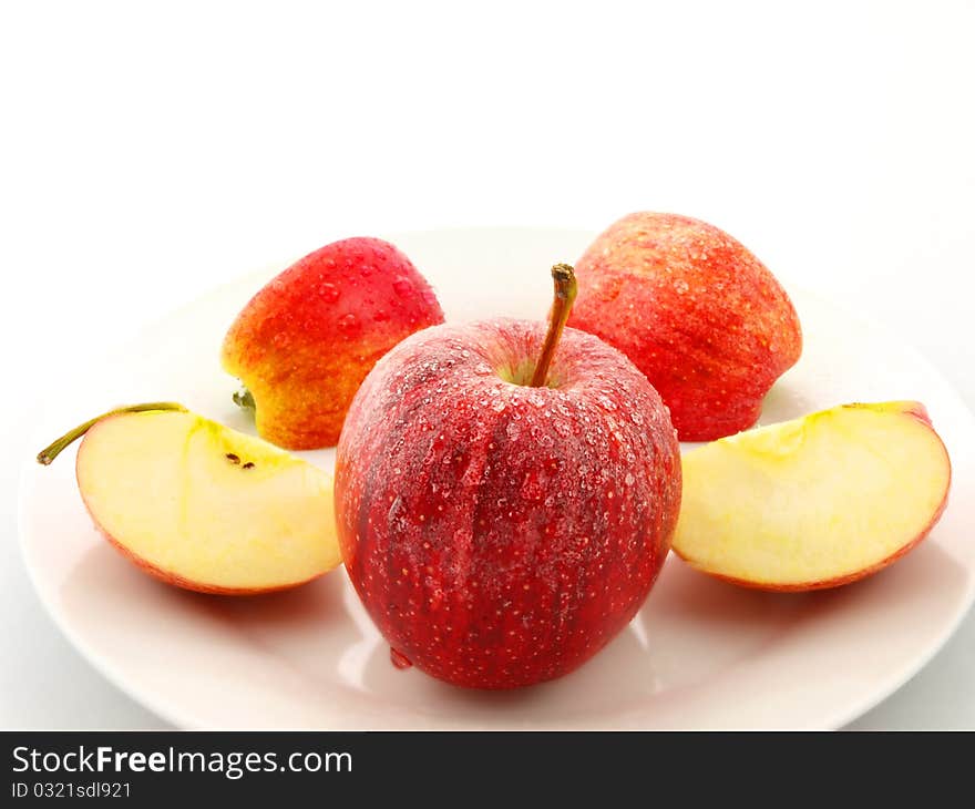 Red apples on white plate towards white background